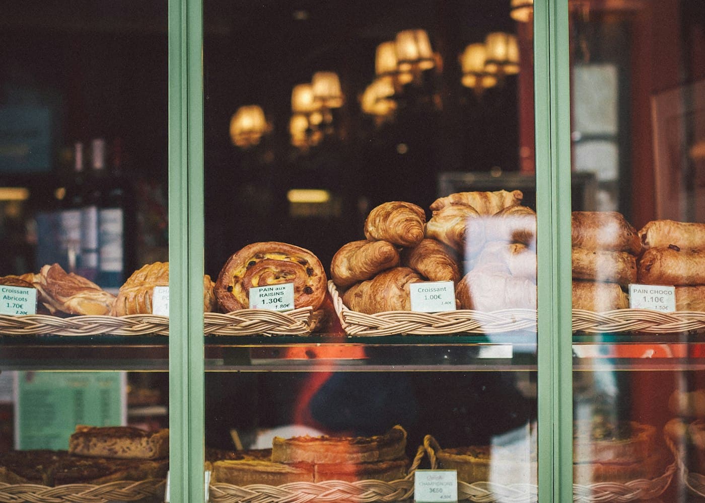 A bakery display counter full of pastries under warm light